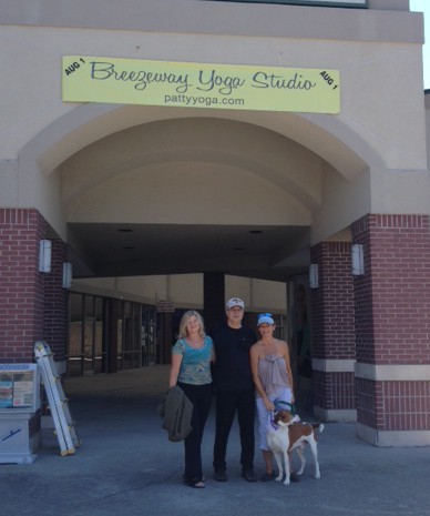 Kathy Hart, Troy Burklow, Patty and Harris the Dog show pose in front of the banner they hung on the entrance to the breezeway.